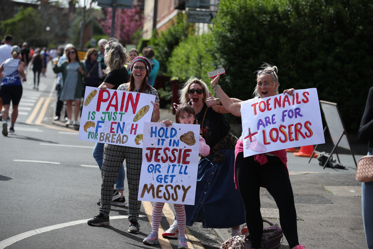 Spectators holding up handmade signs