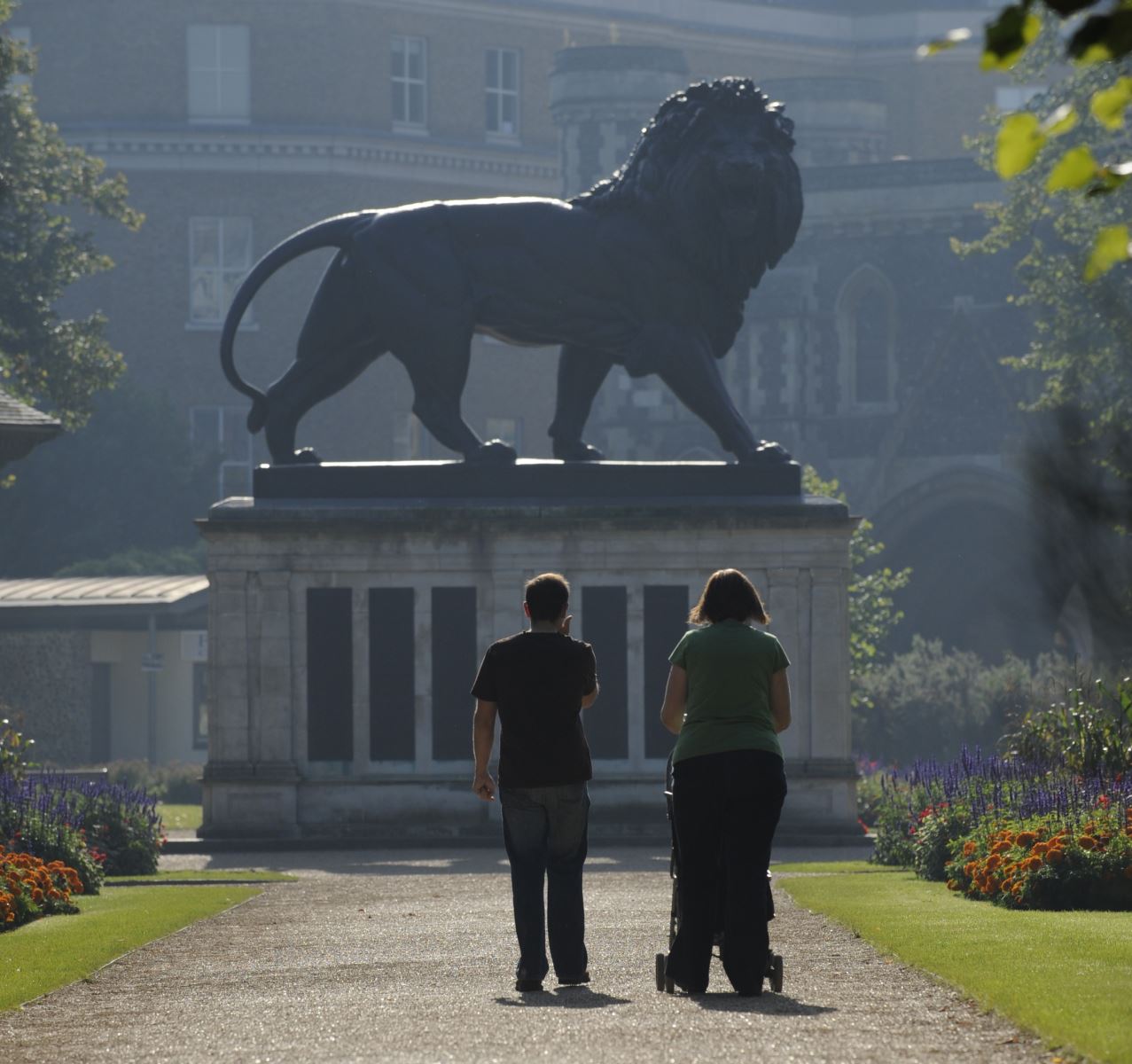 Two people looking at the Maiwand Lion statue, Forbury Gardens, Reading